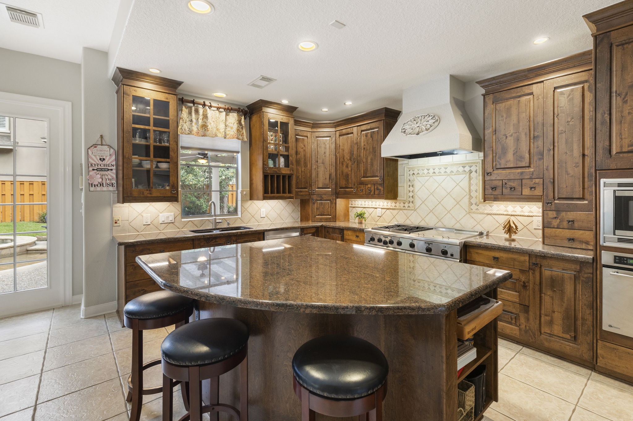 107 East Mirror Ridge Circle The Woodlands, TX 77382 - Photo 22 of 47 a kitchen with a sink a stove and chairs
