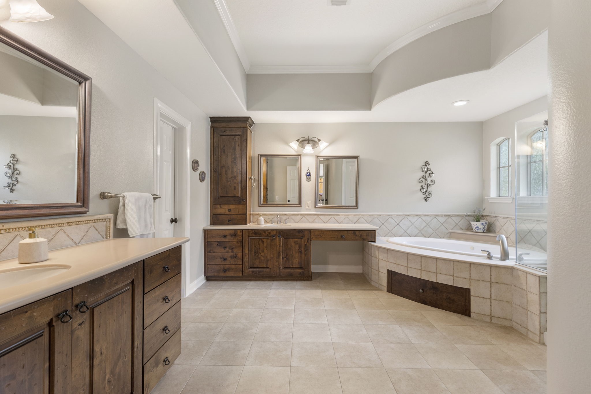 107 East Mirror Ridge Circle The Woodlands, TX 77382 - Photo 32 of 47 a bathroom with a double vanity sink large mirror and a bathtub