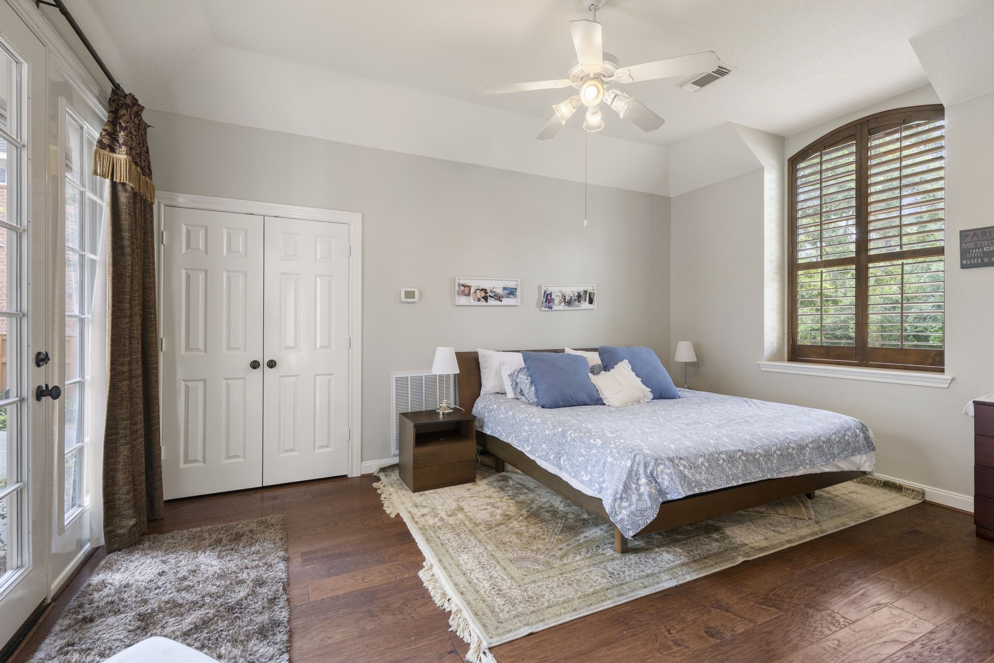 107 East Mirror Ridge Circle The Woodlands, TX 77382 - Photo 34 of 47 a bedroom with a large bed and a chandelier