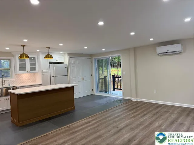 a view of kitchen with stainless steel appliances granite countertop a stove and a wooden floors