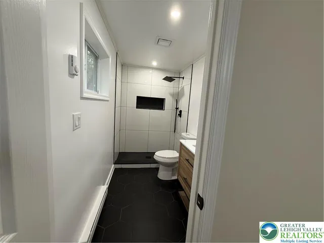a bathroom with a toilet and a shower