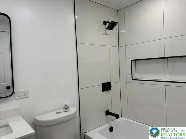 a bathroom with a toilet sink and mirror