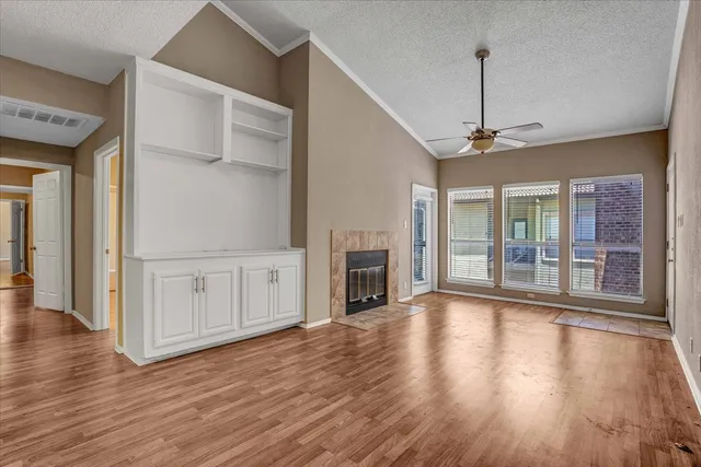 a view of a livingroom with wooden floor a fireplace and window