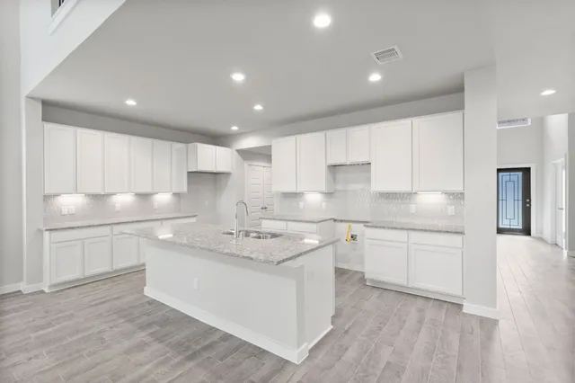a kitchen with granite countertop white cabinets and white appliances