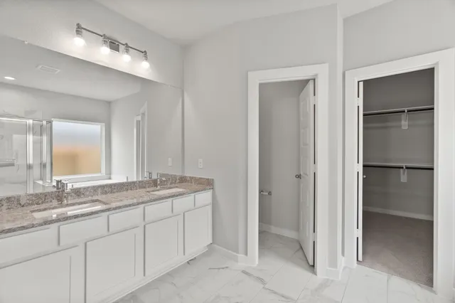 a bathroom with a granite countertop sink mirror and cabinets