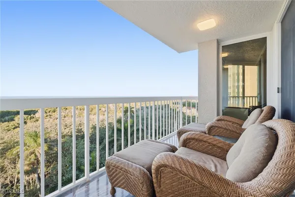 a balcony with furniture and a floor to ceiling window