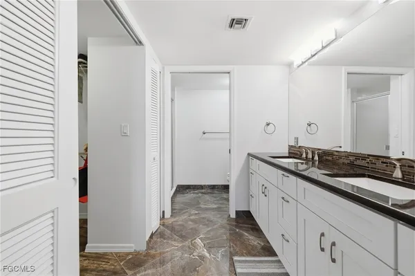 a bathroom with a granite countertop sink a toilet and a mirror