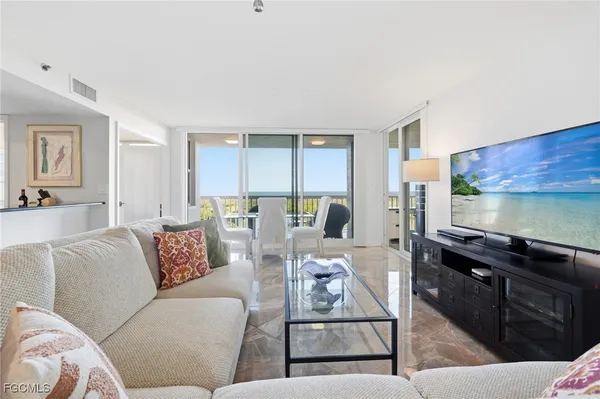 a living room with furniture a flat screen tv and a table