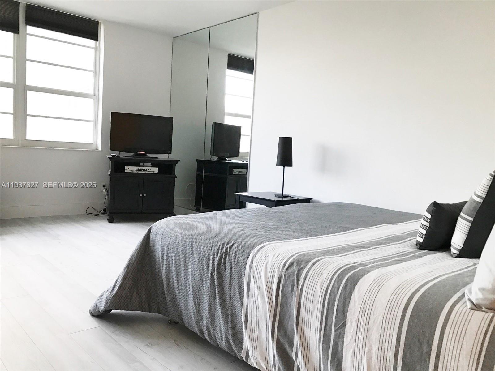 100 Lincoln Road, Unit 1024 Miami Beach, FL 33139 - Photo 5 of 15 a bedroom with a bed and a flat tv screen on a dresser