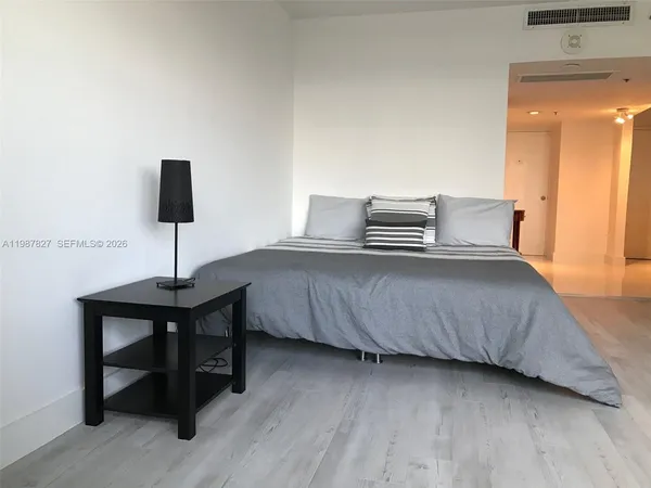 a bedroom with a bed and a flat screen tv
