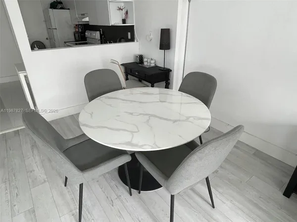 a kitchen with a table chairs and a wooden floor