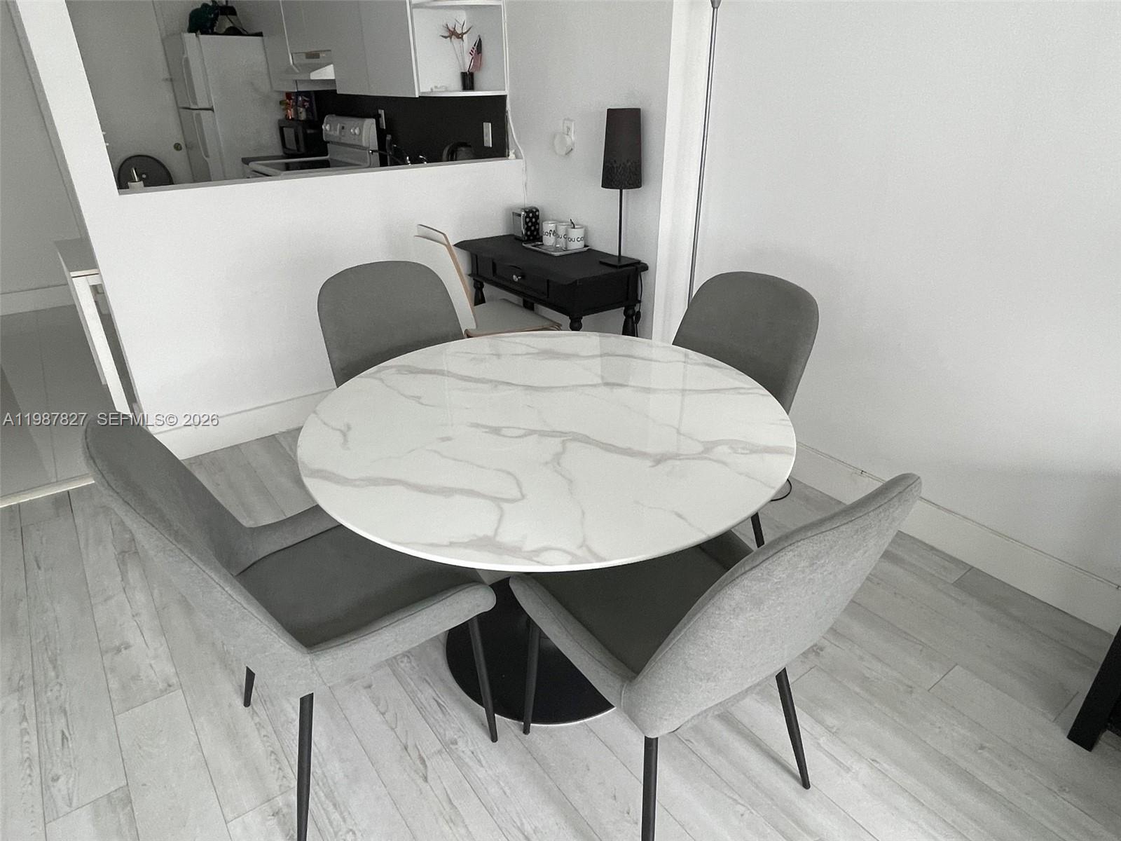 100 Lincoln Road, Unit 1024 Miami Beach, FL 33139 - Photo 9 of 15 a kitchen with a table chairs and a wooden floor