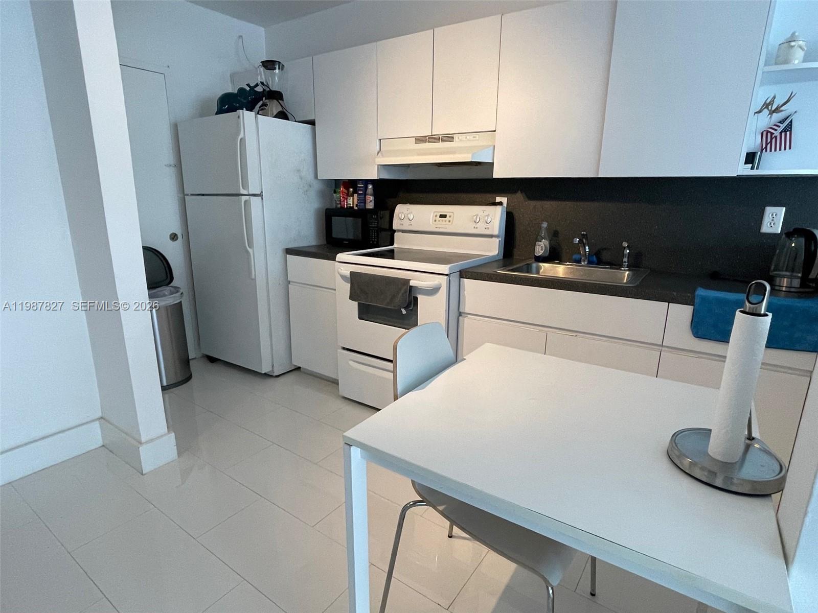 100 Lincoln Road, Unit 1024 Miami Beach, FL 33139 - Photo 10 of 15 a kitchen with a refrigerator sink stove and cabinets
