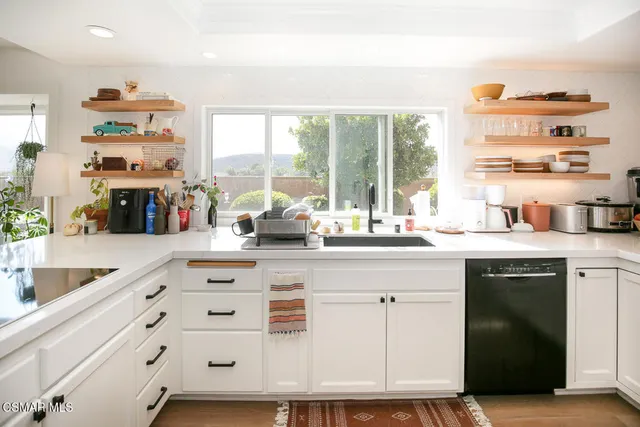a kitchen with cabinets a sink and a large window