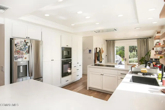 a large white kitchen with a large window