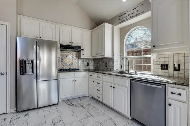 a kitchen with stainless steel appliances granite countertop a refrigerator sink and cabinets