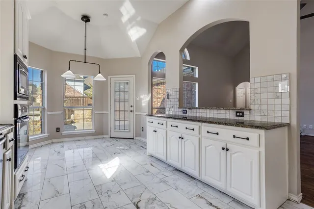 a spacious bathroom with a granite countertop sink a mirror and a shower