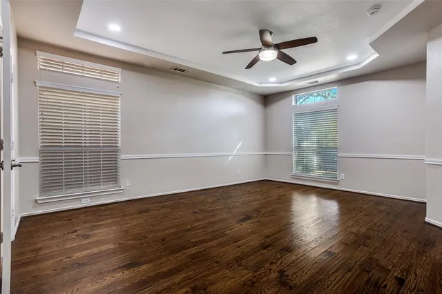 a view of wooden floor and a chandelier fan in a room