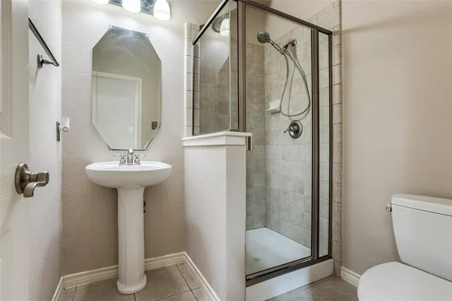 a bathroom with a shower sink mirror and toilet