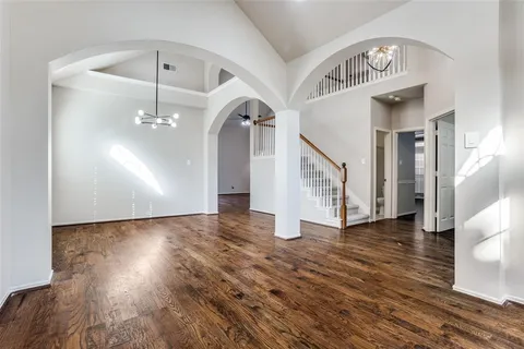 a view of a hallway with wooden floor and staircase