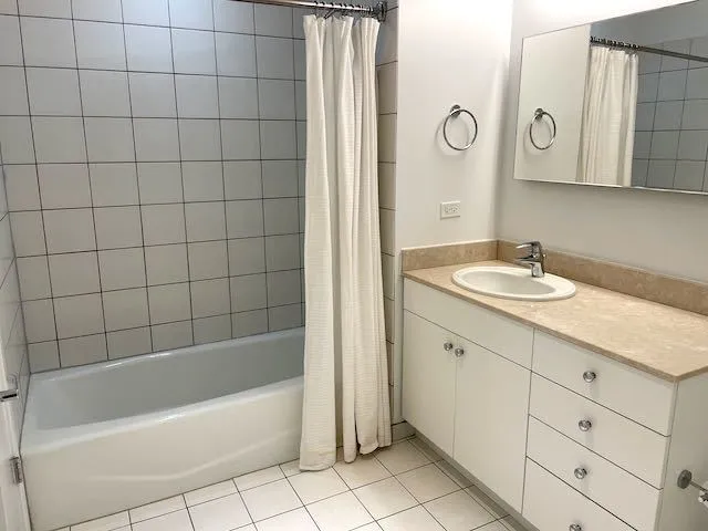 a bathroom with a bathtub a sink a vanity and a shower