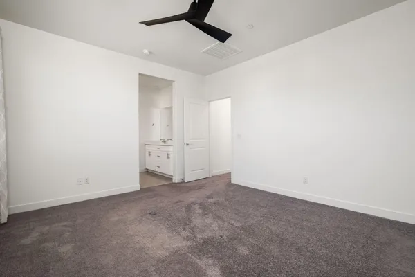 an empty room with closet and windows