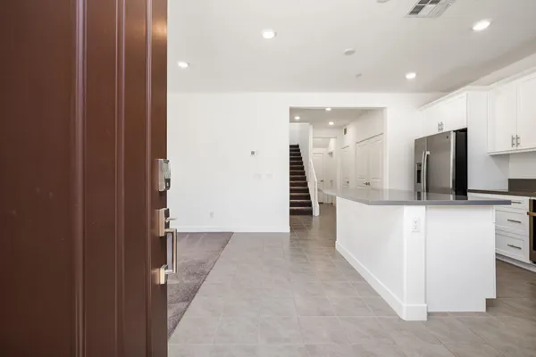 a view of a kitchen with refrigerator and white cabinets