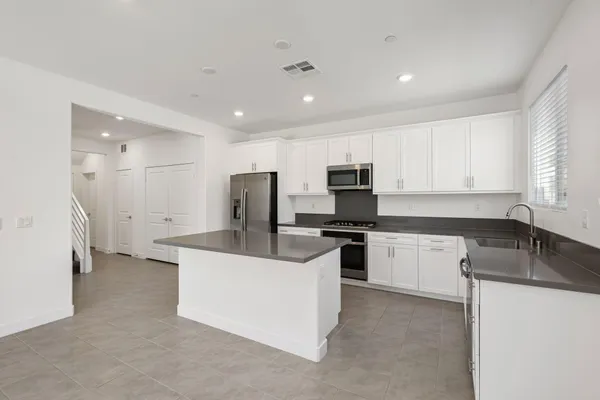 a kitchen with stainless steel appliances a sink stove and refrigerator