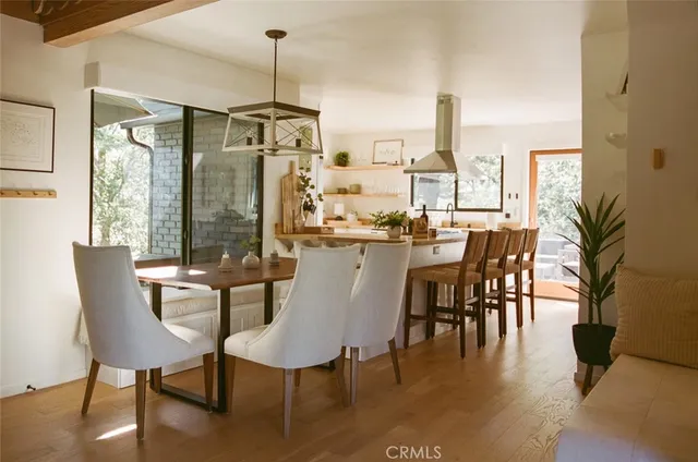 a dining room with furniture a chandelier and wooden floor