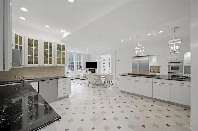 a kitchen with stainless steel appliances a sink a stove a table and chairs