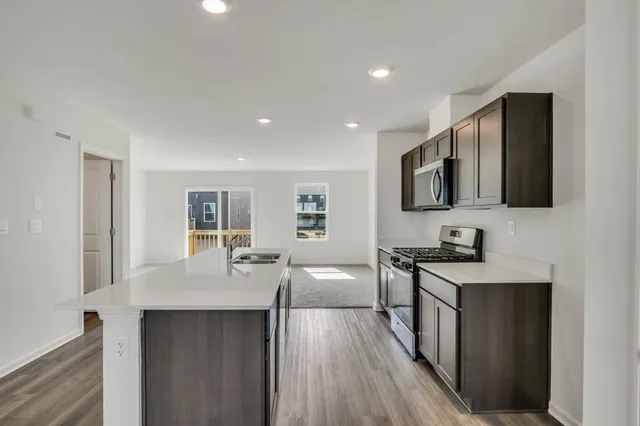 a kitchen with granite countertop a sink stove top oven and wooden floor