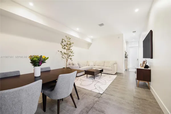 a living room with furniture potted plant and a flat screen tv
