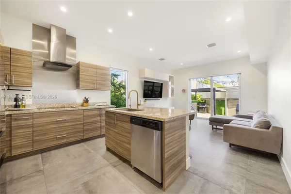 a living room with kitchen island furniture and a flat screen tv