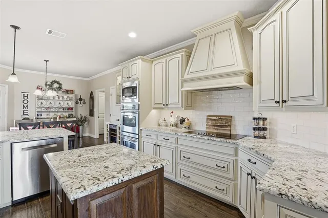 a kitchen with granite countertop cabinets stainless steel appliances and a counter space