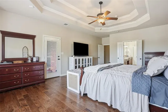 a bedroom with a bed dresser and a flat tv screen