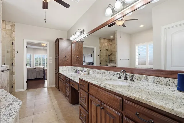 a spacious bathroom with a granite countertop sink a mirror and shower