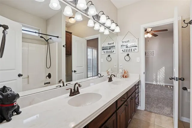 a bathroom with a sink double vanity granite tub shower and a mirror