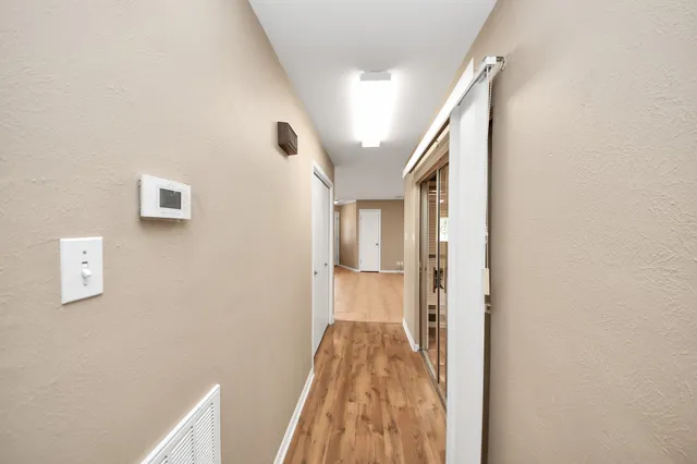 a view of a hallway with wooden floor and staircase