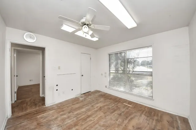 an empty room with a ceiling fan and a window