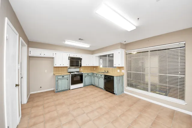 a kitchen with a refrigerator and a stove top oven