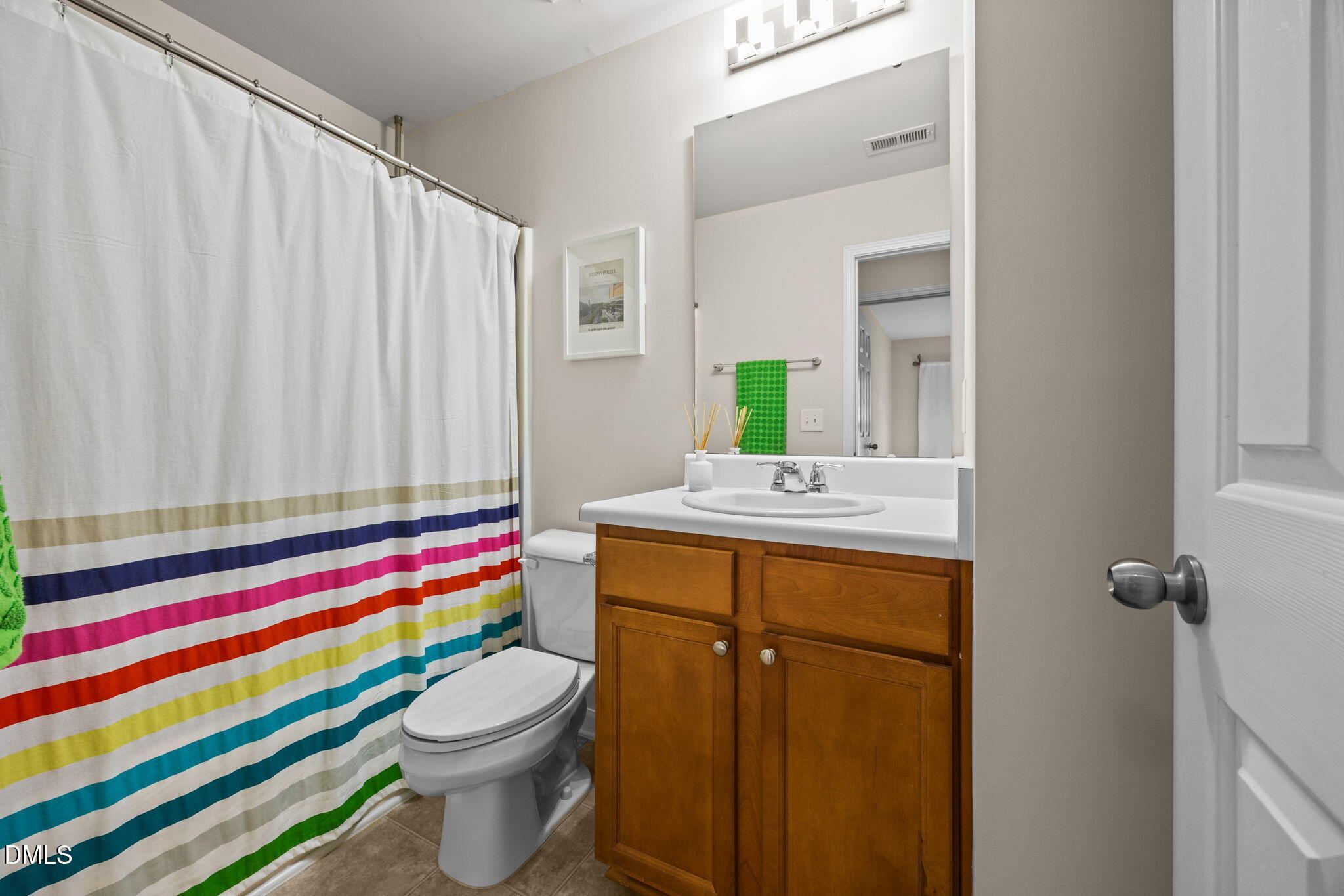 7022 Racine Way Raleigh, NC 27690 - Photo 19 of 26 a bathroom with a sink a toilet and shower curtain