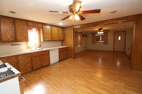 a kitchen with stainless steel appliances granite countertop a sink window and cabinets