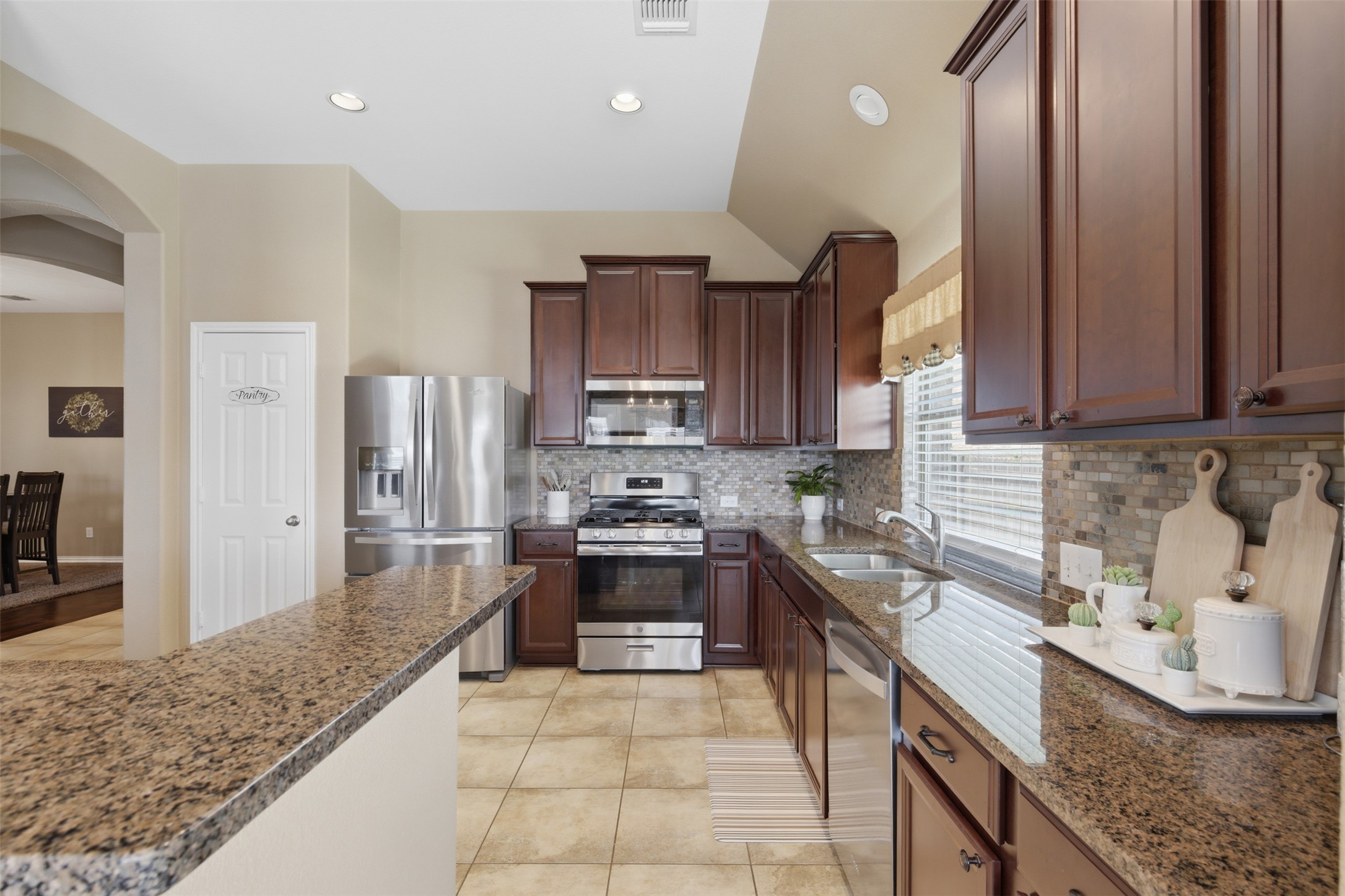 2568 Santa Barbara Loop Round Rock, TX 78665 - Photo 10 of 34 a kitchen with stainless steel appliances granite countertop a sink stove and refrigerator