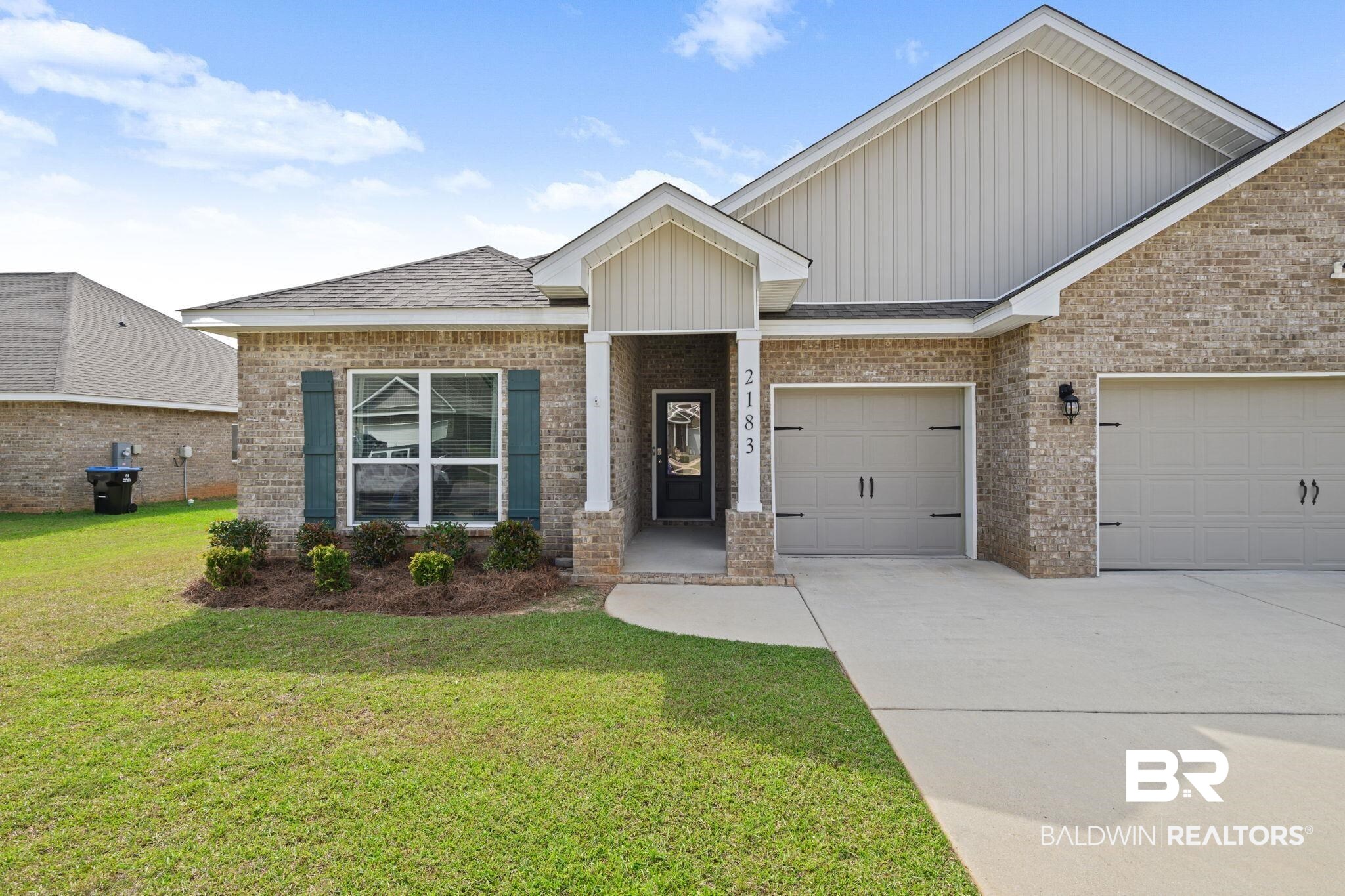 2183 Meadowview Loop Semmes, AL 36575 - Photo 4 of 58 Single story home featuring concrete driveway, a front lawn, board and batten siding, and brick siding