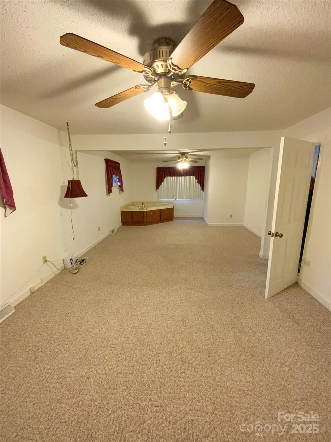 167 East High Road Bostic, NC 28018 - Photo 13 of 28 en empty room with windows and ceiling fan