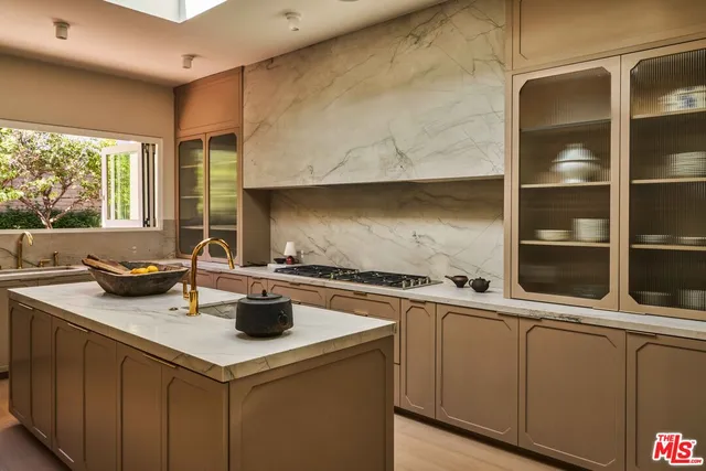 a kitchen with stainless steel appliances granite countertop a sink a stove and a wooden cabinets