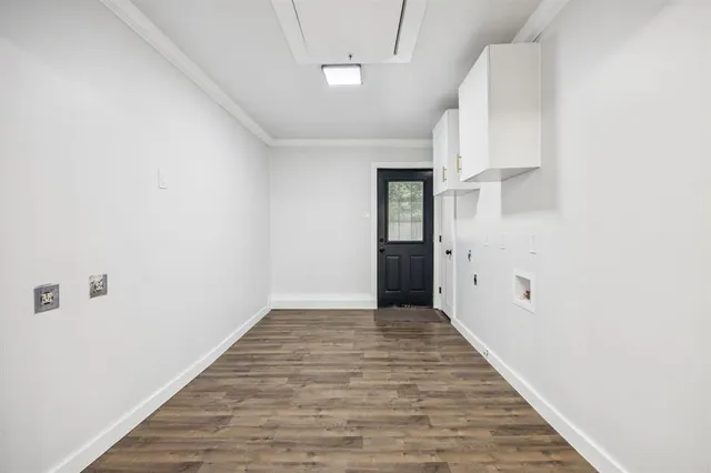 a view of an empty room with wooden floor
