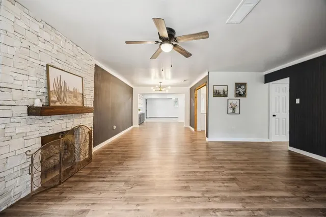 a view of an empty room with window and wooden floor