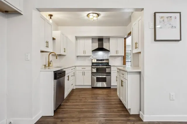 a kitchen with white cabinets and stainless steel appliances