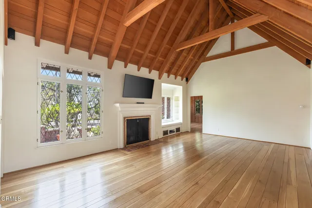 a view of empty room with wooden floor and fireplace